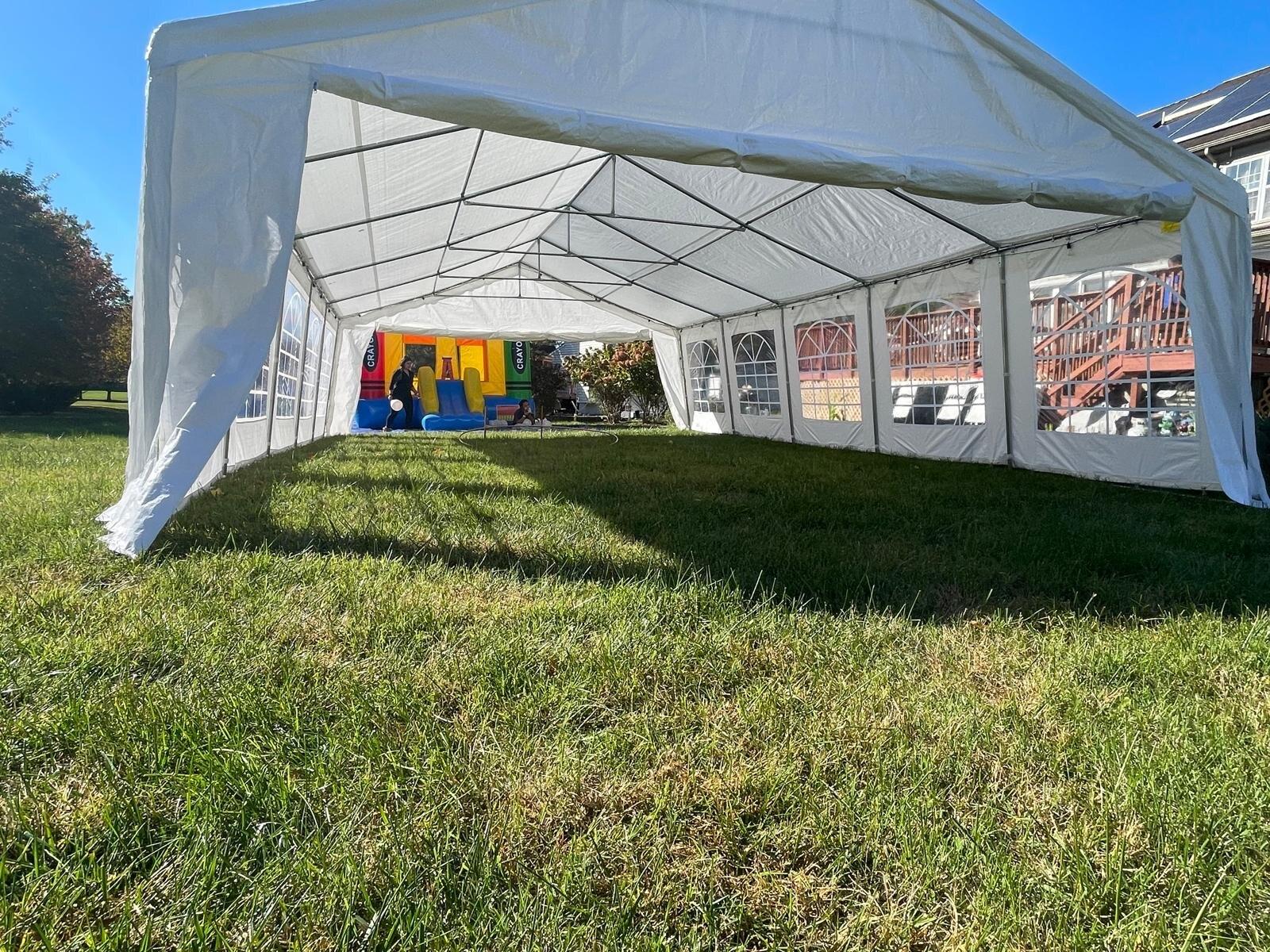 White 20x20 event tent set with tables and chairs.